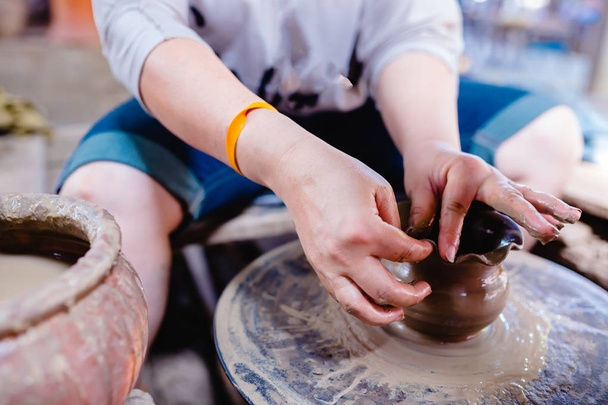 Woman moulding clay on pottery wheel - Photo, Image