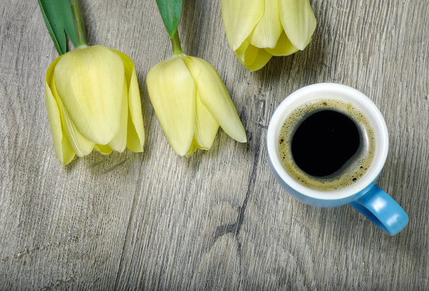 cup of coffee and tulips on wooden table. copy spaces. - Φωτογραφία, εικόνα