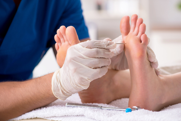 Podologe behandelt Füße während des Eingriffs - Foto, Bild