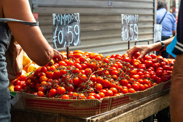 Het kopen van verse tomaten op de boerenmarkt - Foto, afbeelding