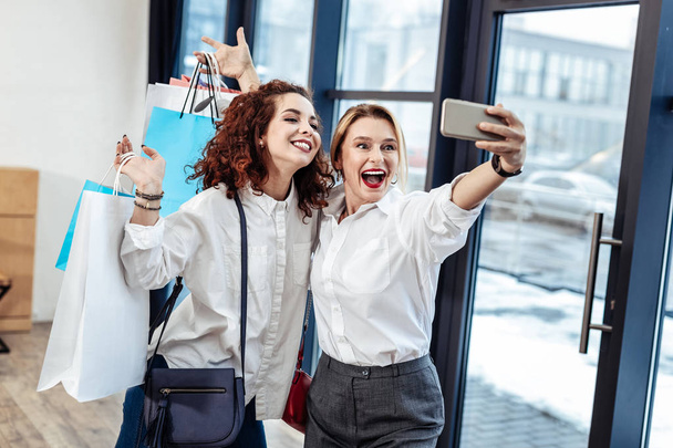 Happy mother and daughter making selfie after successful shopping - Photo, image