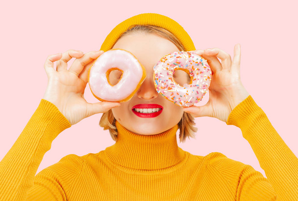 Funny woman  with colorful donuts against her eyes. - Foto, afbeelding