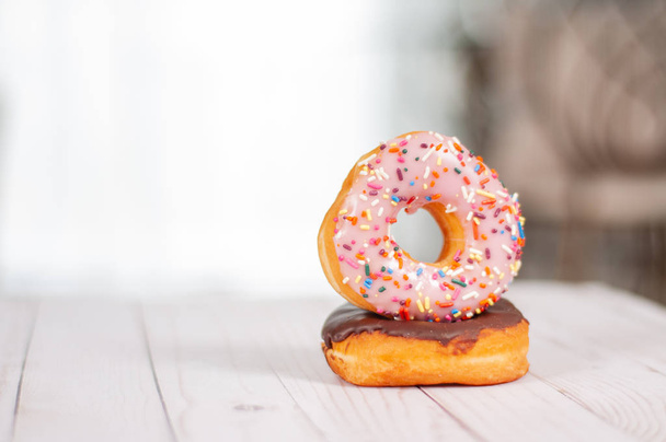 Colorful glazed donuts on wood table. - Photo, Image