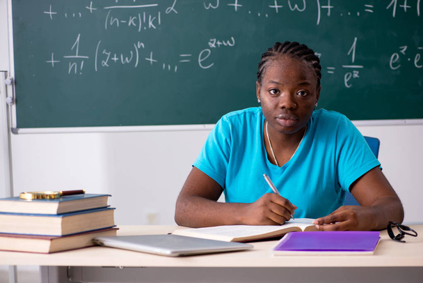 Μαύρο φοιτήτριας μπροστά από μαυροπίνακα   - Φωτογραφία, εικόνα