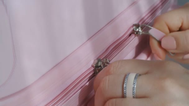 Makro-Nahaufnahme des Reißverschlusses eines Koffers, der von weiblichen Fingern geöffnet und geschlossen wird - Filmmaterial, Video