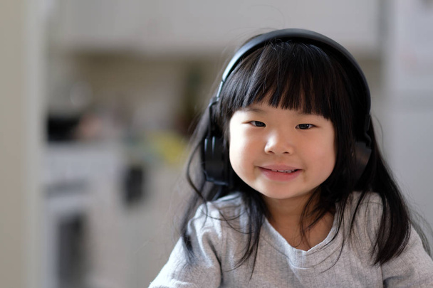 Młoda dziewczyna Azji, ciesząc się, słuchając muzyki na sluchawkach jej - Zdjęcie, obraz