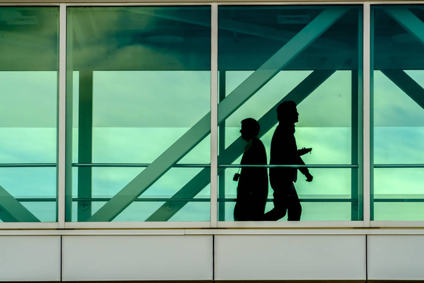 Силуэт людей, видимых через стеклянные окна
 - Фото, изображение