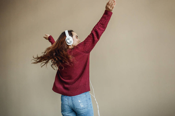 Enjoy the music. Happy young woman pleasing music in headphones. - Фото, изображение