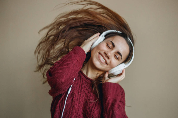 Enjoy the music. Happy young woman pleasing music in headphones. - 写真・画像