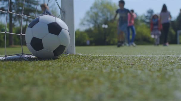 Niños jugando un partido de fútbol, una pelota cerca en el frente, 4k
 - Metraje, vídeo