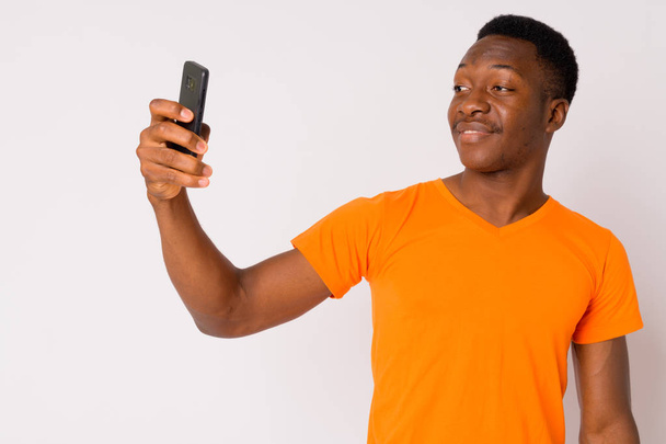Portrait of young handsome African man taking selfie - Photo, Image