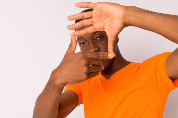 Portrait of young handsome African man focusing with fingers - Foto, afbeelding