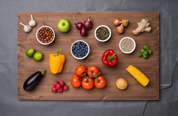 Ingredientes alimenticios saludables: verduras frescas, frutas y superalimentos. Nutrición, dieta, concepto de comida vegana. Fondo de madera - Foto, imagen