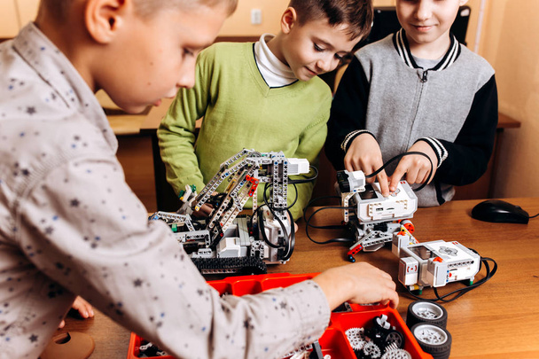 Three happy boys are making robots in the School of Robotics - Photo, Image