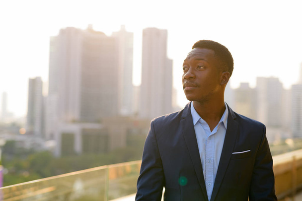 Joven empresario africano pensando en contra de la vista de la ciudad
 - Foto, Imagen