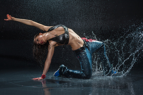 Wet dancing woman. Under waterdrops. Studio photo - 写真・画像