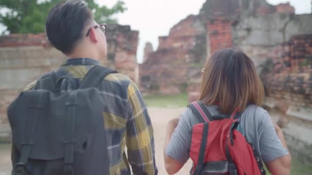Viajante casal asiático passar férias viagem em Ayutthaya, Tailândia, mochileiro casal doce desfrutar de sua jornada no marco incrível na cidade tradicional. Estilo de vida casal viagens férias conceito
. - Filmagem, Vídeo