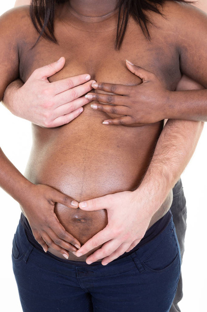 schwangere Afroamerikanerin und ihr kaukasischer Ehemann halten Hand auf Babybauch - Foto, Bild