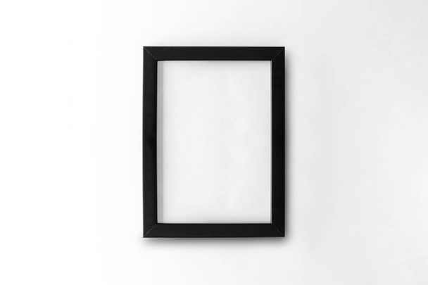 blank black picture frame on white table background. top view - Foto, afbeelding