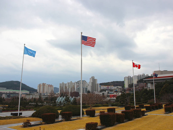 Американский флаг развевается в воздухе мемориального кладбища ООН в Пусане, Южная Корея, Азия
 - Фото, изображение