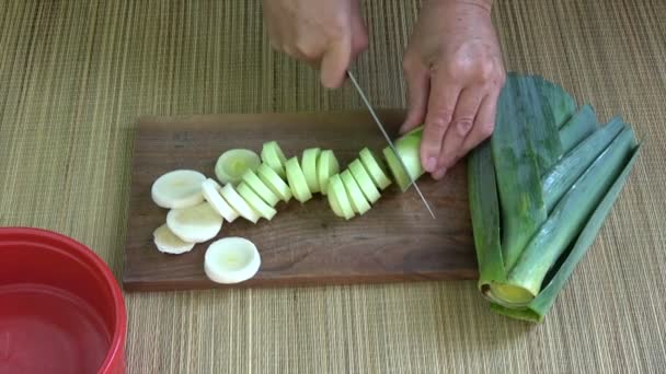Corte legumes de alho-porro fresco em tábua de corte de madeira
 - Filmagem, Vídeo