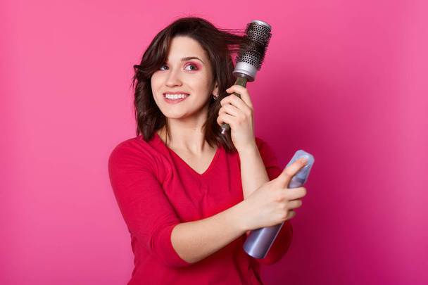 Positive smiling woman with straight brown hair, uses hairspray  - Foto, Imagen