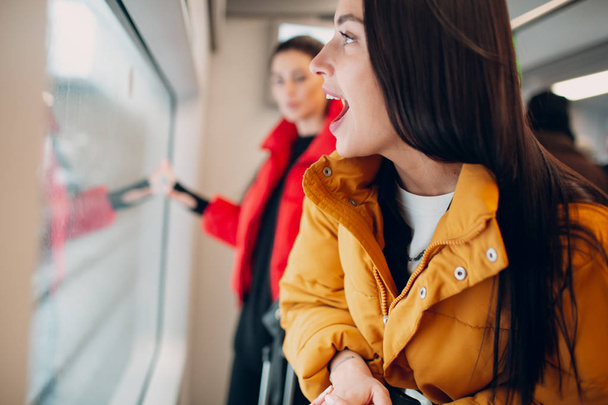 Giovane positivo femminile guardando treno finestrino. Concetto di amicizia femminile
. - Foto, immagini