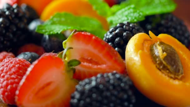 Makro-Nahaufnahme rotierender gemischter Sommerfrüchte auf Holztisch. - Filmmaterial, Video