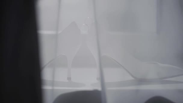 Két jegygyűrű gördülő együtt közelében menyasszony esküvői cipők. - Felvétel, videó