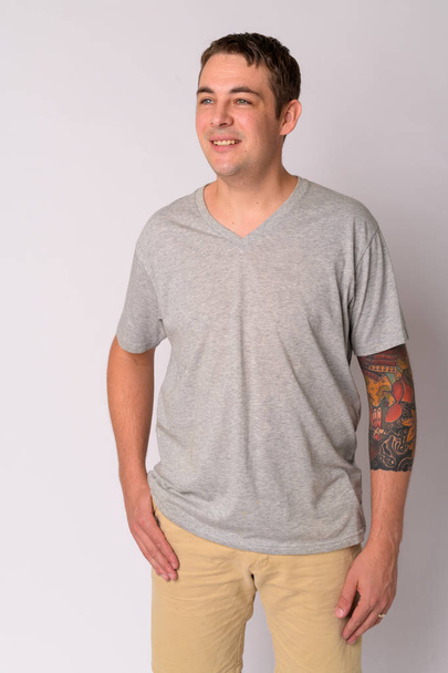 Portrait of happy handsome man with arms tattoos thinking - Foto, imagen