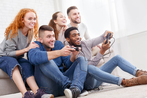 Φίλους παίζοντας βιντεοπαιχνίδια, έχοντας διασκέδαση στο σπίτι - Φωτογραφία, εικόνα