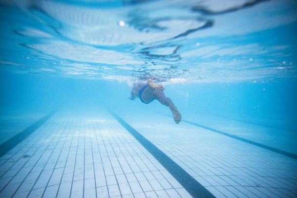 male swimmer diving and swimming in a swimming pool to train - Foto, Bild