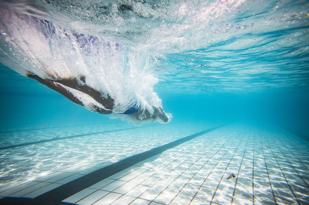 férfi úszó búvárkodás és úszás a medencében a vonat - Fotó, kép