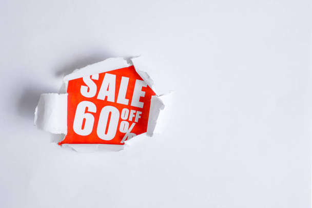 The concept of sales in the form of discounts 60. The inscription on the red paper coming out of the white paper. Copy space. - Фото, изображение