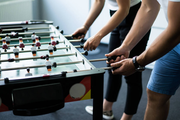 happy managers playing table football at office and having fun together - Photo, image