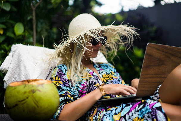 Жінка-фрілансер, туристичний блогер працює на ноутбуці. сидячи на
 - Фото, зображення
