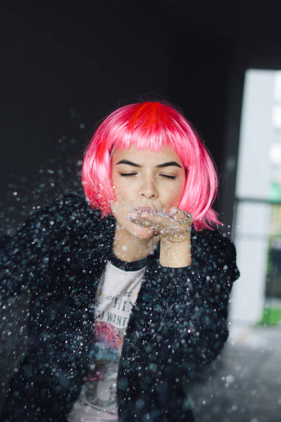 portrait of a woman in pink wig with silver sequins in her hands - Photo, image