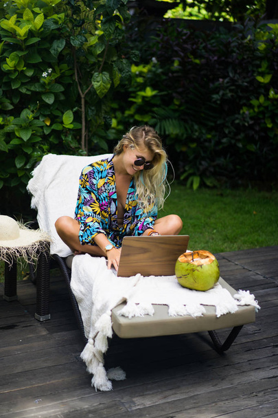 Woman freelancer, travel blogger works on a laptop. sitting on a - Valokuva, kuva