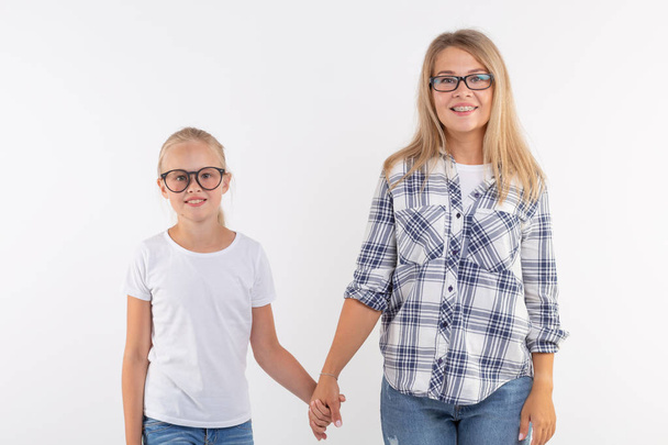glückliche junge Mutter und lachendes Kind mit Modebrille haben Spaß auf weißem Hintergrund - Foto, Bild