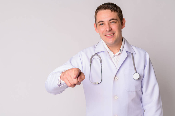 Porträt eines glücklichen gutaussehenden Mannes Arzt zeigt auf Kamera - Foto, Bild
