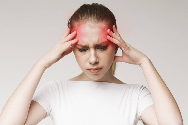 Vrouw lijden aan hoofdpijn, het aanraken van haar tempels - Foto, afbeelding