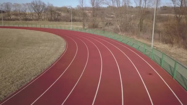 Span along the red running track in the stadium. Video filming from the air of an element of a sports complex. Outdoor coating for sports. The place for competitions in athletics with the height of a  - Footage, Video