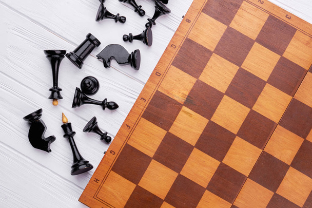 Шахматные фигуры и игровая доска на деревянном фоне
. - Фото, изображение