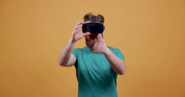 Young man with big beard in a virtual reality set using his hands - Záběry, video