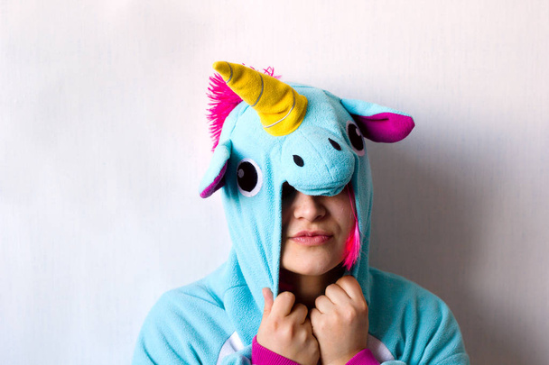 cute girl in a pink wig in kigurumi unicorn pyjamas  costume - Zdjęcie, obraz