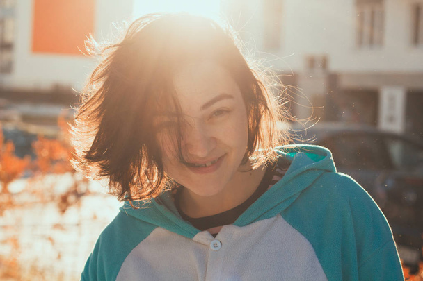 beautiful cute young woman portrait in blue fleece jacket with contoured sunlight - Photo, image