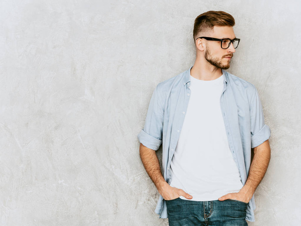 Portrait of handsome serious hipster lumbersexual businessman model wearing casual shirt clothes. Fashion stylish man posing against gray wall in spectacles - Photo, Image