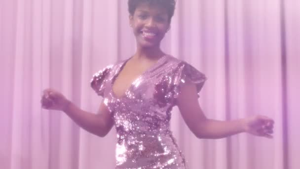 черный смешанной расы женщина с короткой стрижкой и вьющиеся натуральные волосы носит блестки блестящее платье в розовом
 - Кадры, видео