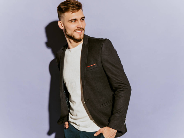 Portrait of handsome smiling hipster lumbersexual businessman model wearing casual black suit. Fashion stylish man posing in studio - Фото, изображение