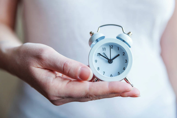 Mujer mujer manos sosteniendo timbre doble campana vintage reloj despertador clásico
 - Foto, Imagen